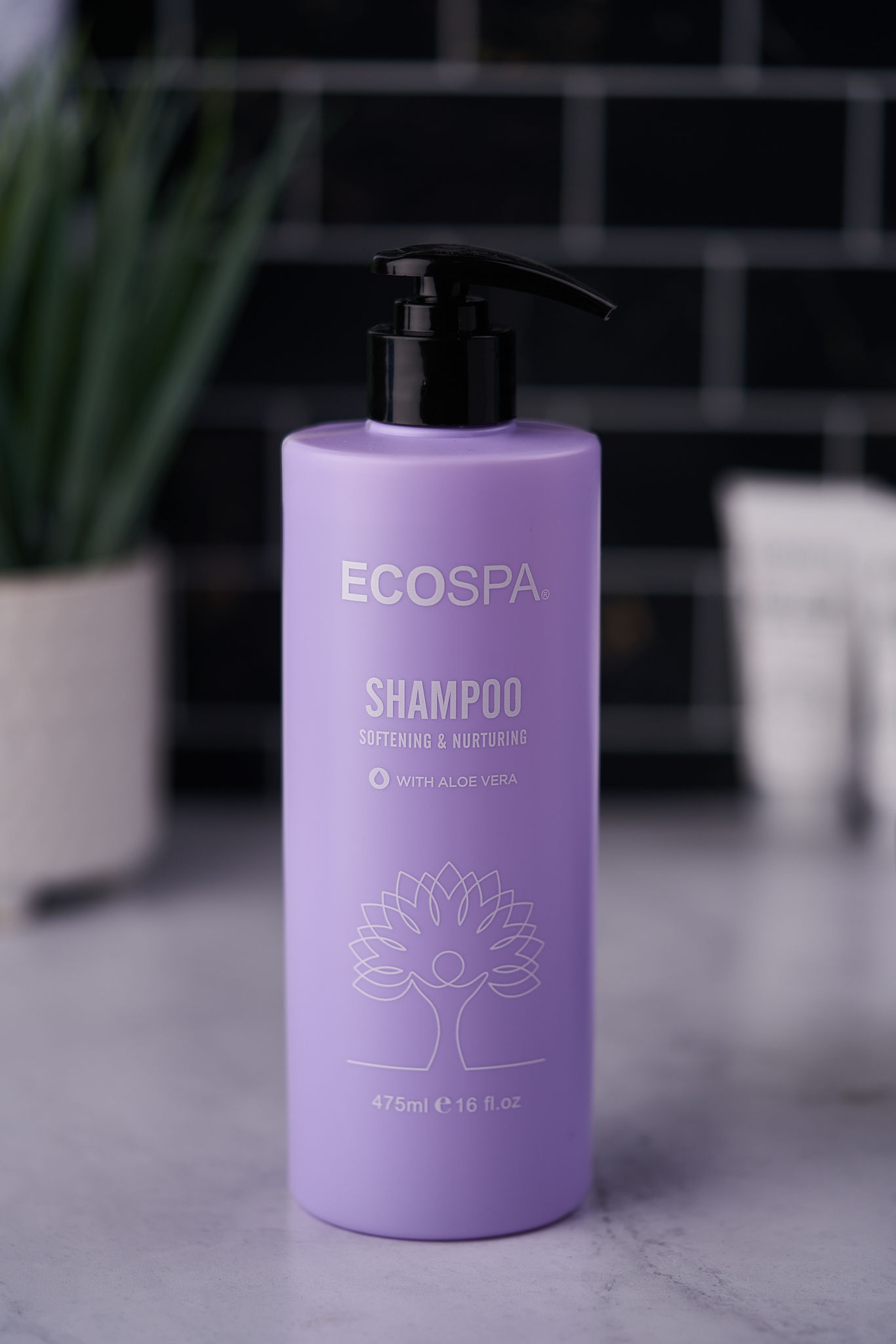 Lavender ECOSPA shampoo bottle (Softening & Nourishing with Aloe Vera) on a marble counter 