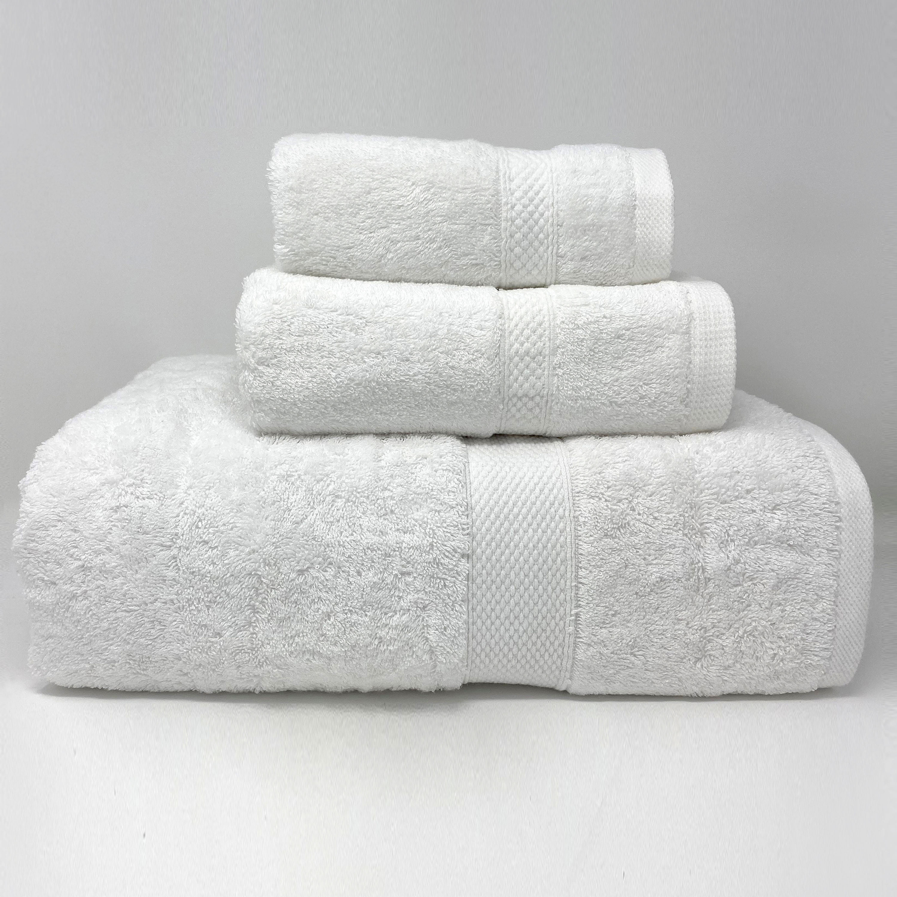 A stack of three white bath towels with a textured cam border design, showing softness and quality