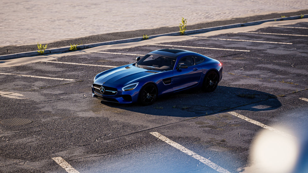 Mercedes-AMG GT in vibrant blue parked in an empty lot during a picturesque sunset, showcasing its sleek design and performance-oriented aesthetic.