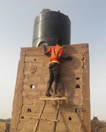 Ein junger Mann steht auf einer Leiter und überprüft den Turm des neuen Brunnens.