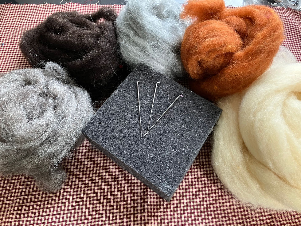 Pictured here is a high-density foam felting mat, various needles, and various wool roving.