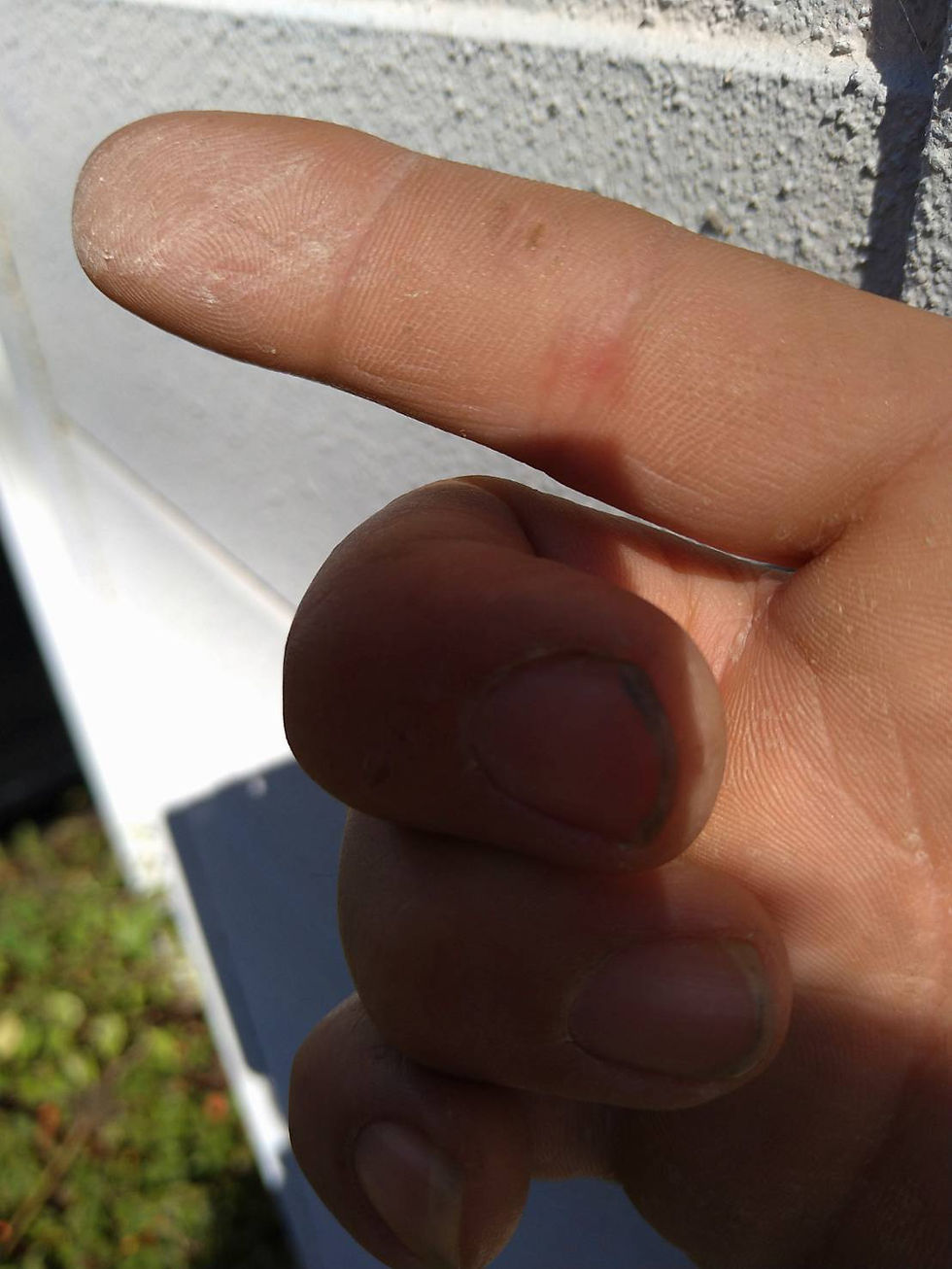 外壁を手で触ってチョーキングの状態を確認している、大府市・名古屋市周辺の住宅診断の様子