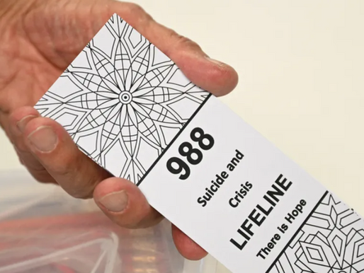 A bookmark for children with the 988 suicide and crisis lifeline emergency telephone number is displayed by Lance Neiberger, a volunteer with the Natrona County Suicide Prevention Task Force, while they speak about mental health and suicide awareness in Casper, Wyoming on August 14, 2022. Sixteen years ago, after his son died by suicide, Lance Neiberger thought of taking his own life. Instead, the petroleum engineer — who lives in central Wyoming — is spearheading the difficult battle to curb the western US state’s suicide rate, the highest in the nation. (Photo by Patrick T. FALLON / AFP) (Photo by PATRICK T. FALLON/AFP via Getty Images)