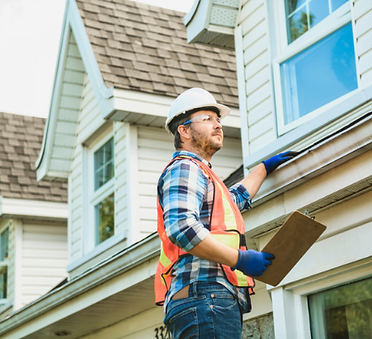 Worker inspecting exterior trim on a house