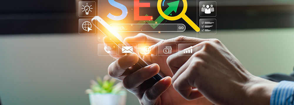 Hands holding a smartphone above a laptop keyboard with online and social media icons and SEO floating around.