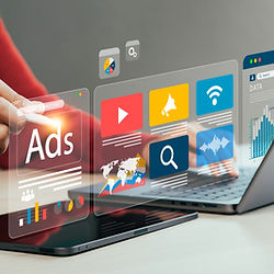 Laptop and smartphone displaying digital advertising and social media icons.