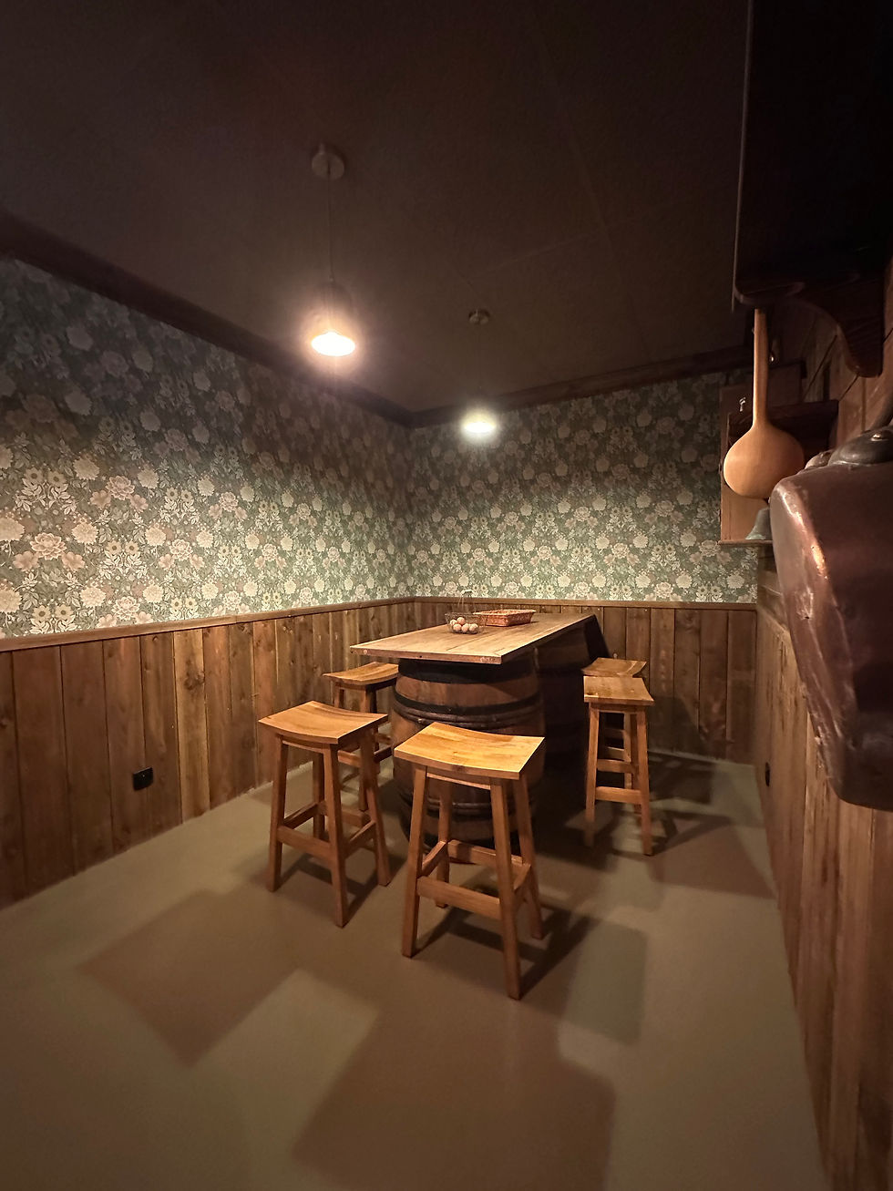 Petite salle de réunion d’O’Fun Park avec table haute en bois, tabourets, papier peint et sol en bét