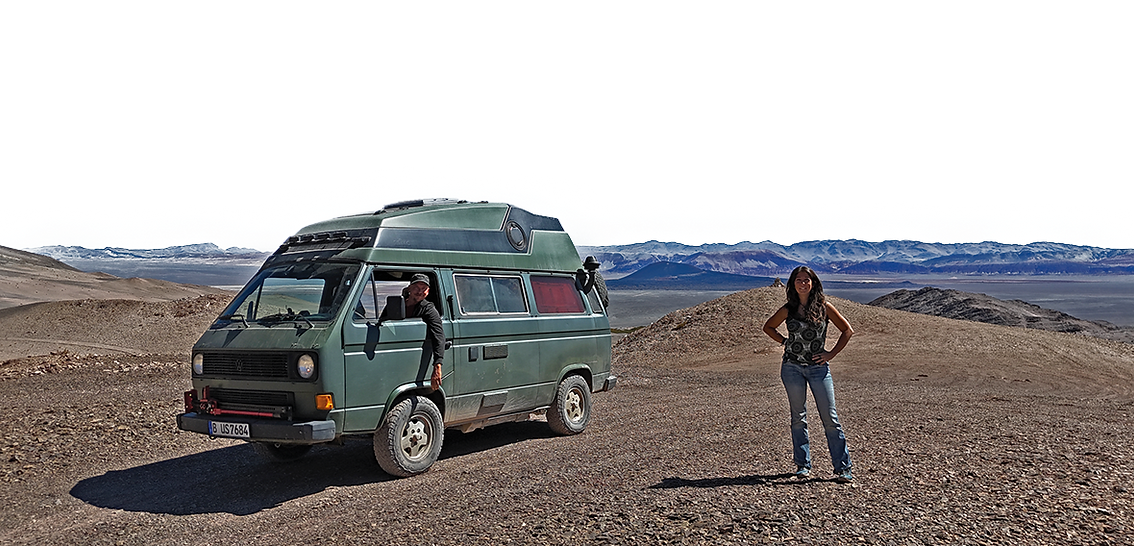 Reisende mit VW Bus in der Wüste