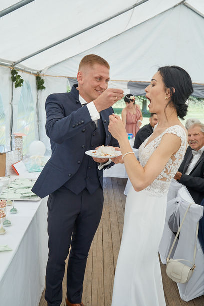 Braut und Bräutigam kosten den Kuchen 