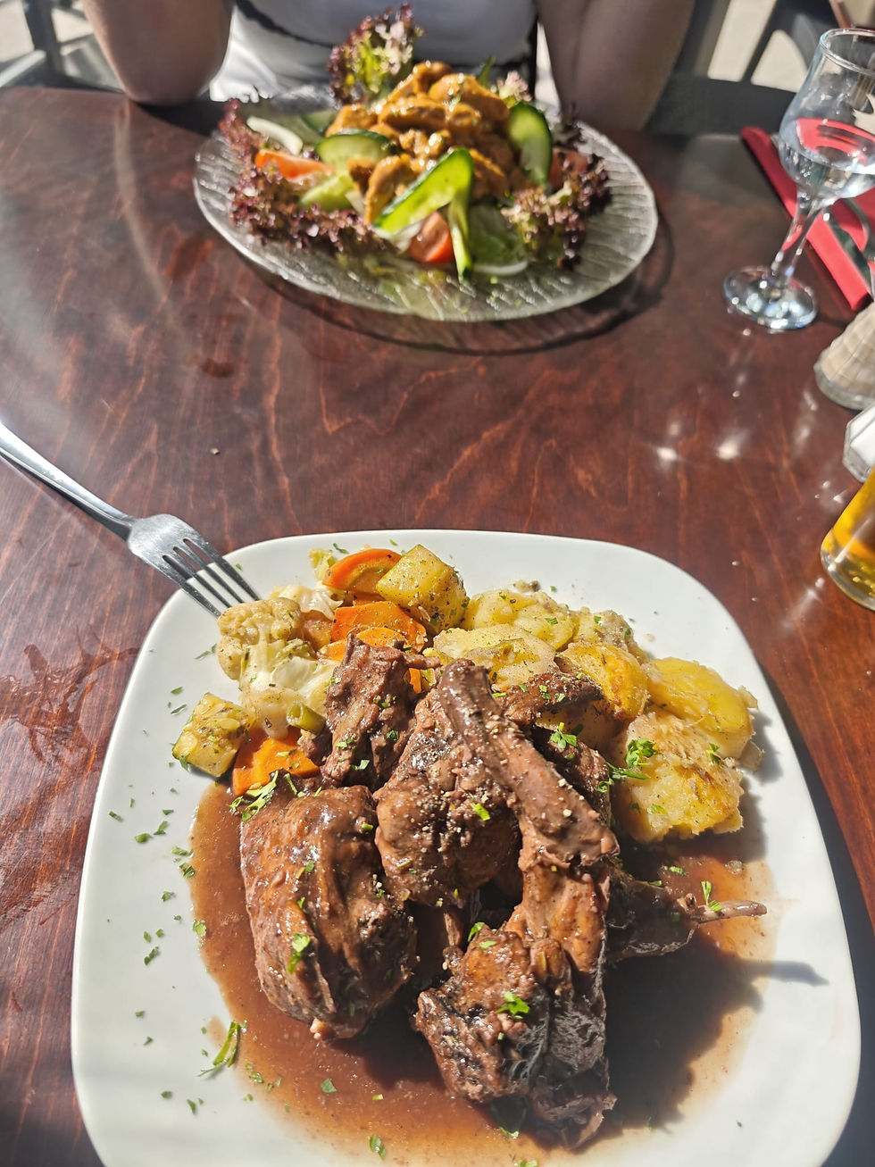 Maltesisches Kaninchengericht im Vordergrund und Hähnchensalat im Hintergrund