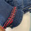 Thumbnail: Close-up of Jeans Jacketfrom America Proud collection. Dark denim with red braided trim detail.