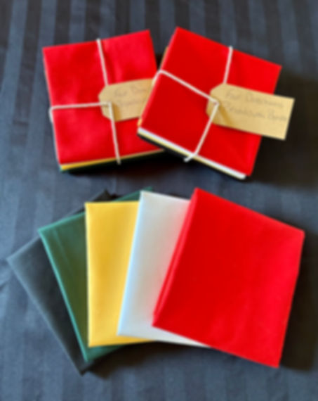 2 broad cloth bundles with black, green, yellow, white, red laid out in front