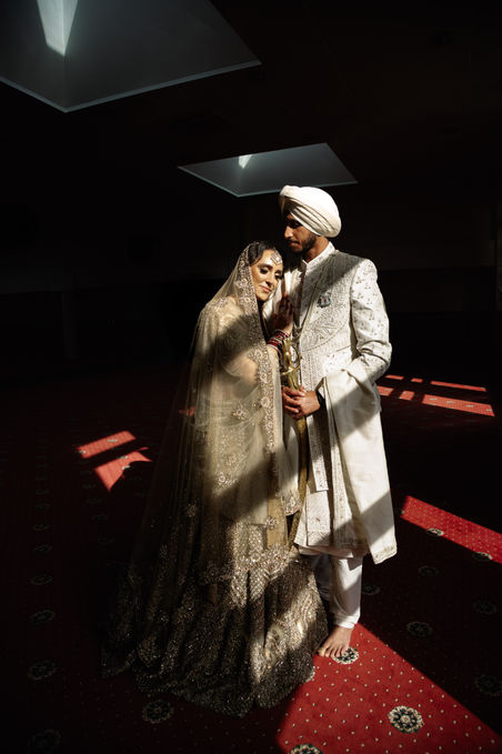 Sikh bride and groom standing in soft golden light after their wedding ceremony - cinematic editorial portrait by Noelle Vaughn Wedding Photography.