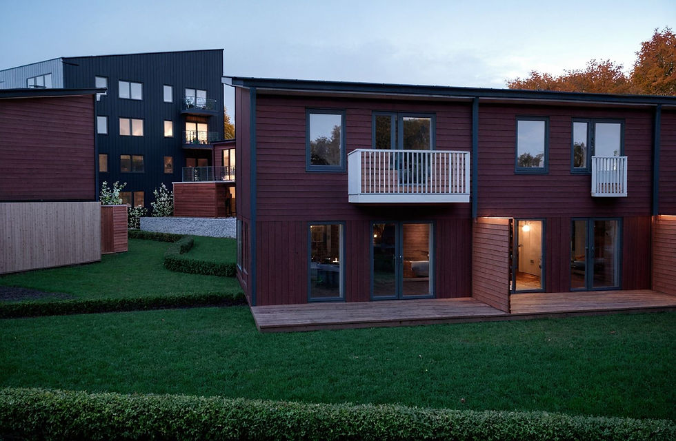 Townhouse, wooden planks, balcony, windows, grass, shrubs, autumn trees, overcast. (1).jpe