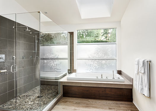 Large furnished bathroom in luxury home with hardwood floor, shower, and bathtub.jpg