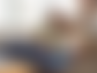 African American father reading a children’s book with his young son on a couch, encouraging early literacy and a love of reading.