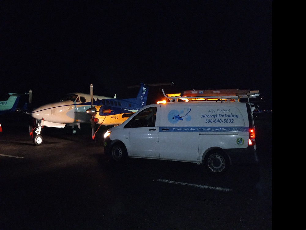 Exterior of a Beechcraft B300 airplane at night in front of a work van