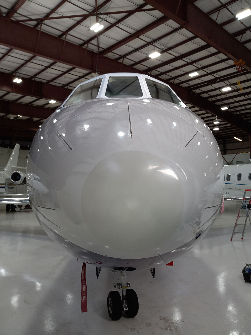 Exterior nose of Dassault Falcon 200 EX aircraft inside of a hanger