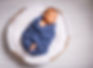 newborn-baby-enveloped-blue-scarf-sleeps-white-pillow.jpg