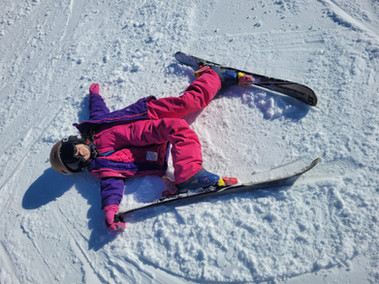 Una niña toma un descanso en la nieve durante su día de ski en el cerro catedral, en argentina