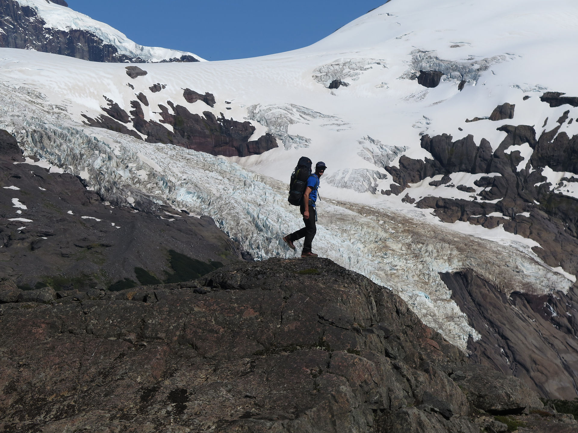 Una persona posa para una foto durante una expedición de trekking en Bariloche con glaciares de fondo pertenecientes al cerro Tronador en el Parque Nacioanal Nahuel Huapi, en cercanías de Bariloche, Argentina