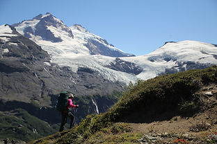 Una chica hace trekking con el cerro tronador de fondo durante una travesia entre laguna ilon y el refugio agostino rocca en la zona de paso de las nubes.