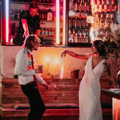 bride and groom dancing in neon pink lit room at 