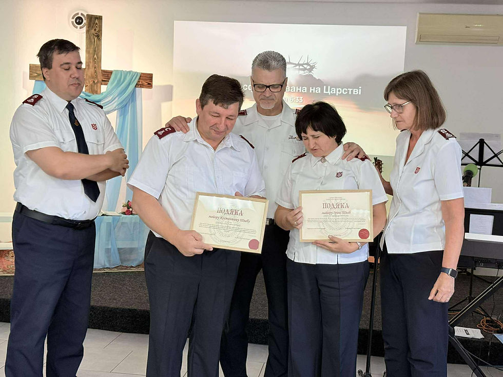 Territorial leaders pray for Majors Konstantyn and Irina Shvab, Ukraine Divisional Leaders, after presenting them with a certificate for 20 years of service as officers.