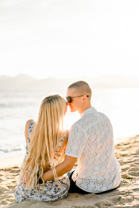 A couple enjoys a golden hour kiss on the beach in Cannes, captured during their photo session.