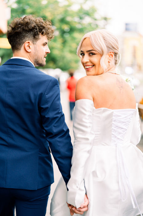 Newlyweds walking hand in hand in Bucharest after their civil wedding, captured by The Bercans.