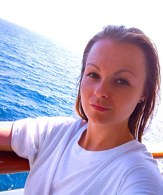 A young woman in a white top. Blue ocean in a background. CORE Online Coaching