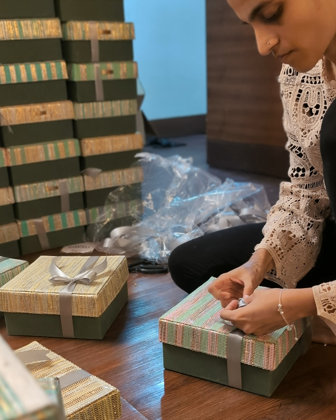 a girl packing a gift hamper and trying a ribbon