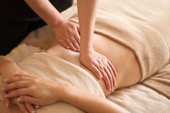 A woman receiving a belly massage at a beauty salon.jpg
