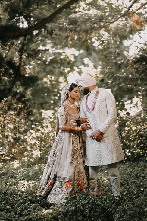 M&B's wedding day turned out to be an stunning celebration that guests will remember for years to come! The bride looked nothing short of radiant, wearing a beautiful gown that sparkled in shades of cream, ivory and gold. The ceremony was artfully decorated with wild garden flowers in soft pinks, vibrant peaches, and rich dark oranges, all surrounded by lush eucalyptus leaves, which together created a romantic and enchanting atmosphere. The reception came alive with the warm glow of candlelight where tables were adorned with vibrant pink, purple, and blue flowers cascading elegantly on the tables. This exquisite setup was further enhanced by the crystal and gold charger plates, complemented by lavender napkins and luxurious pink velvet linens, creating a breathtaking and unforgettable dining experience for everyone present.