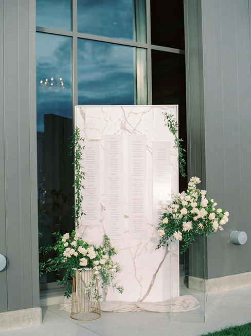 Celebrate the elegance of Denise & Colin's winery wedding, where white florals, black accents, gold details, and a stunning marble finish came in perfect harmony. The reception featured a breathtaking marble wall adorned with delicate white blooms, creating a dreamy backdrop. Dive into the details that made their day unforgettable and discover how this couple infused their unique style into every aspect of their celebration.
D&C elevated their special occasion with our custom square invitations, elegantly printed with stunning rose gold foil. They complemented their wedding celebration with our unique black cotton menus, featuring crisp ink and adorned with a custom gold wax seal for
that perfect finishing. Make your event truly unforgettable with these exquisite details that reflect your personal style.
