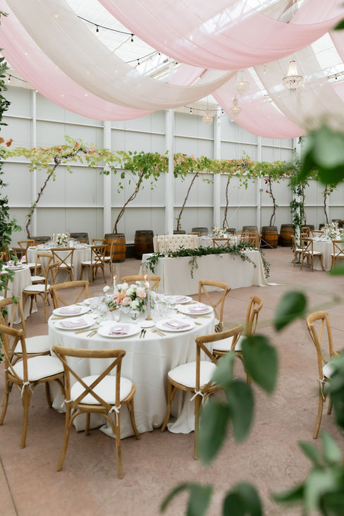Cristina & Justin's Elegant Fairy Tale Garden Wedding Decor Photos.  Surrounded by flowing flowers, trailing vines and gardens. Summer flowers in whites, mauve, pinks and blushes with greenery and grasses.  The tables were done in white linens, white chargers, gold flatware, rose napkins and wood chairs. The wedding stationery was white cotton hand torn menus and place cards with rose ribbon.