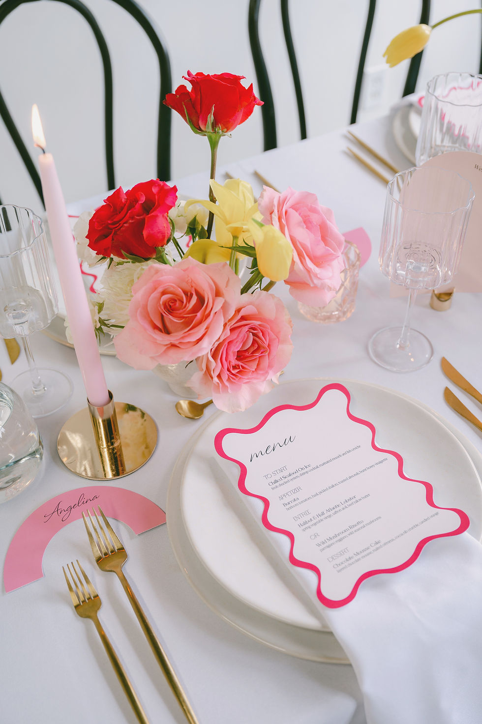 Wedding menu in white and pink with a wavy edge and a pink place card in a rainbow shape