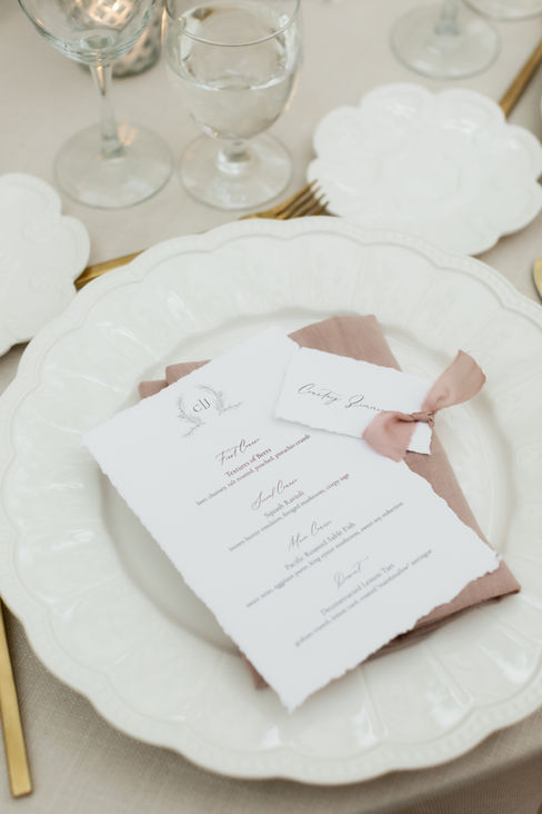 Cristina & Justin's Elegant Fairy Tale Garden Custom Wedding Menu and Place Card Photos.  Surrounded by flowing flowers, trailing vines and gardens. Summer flowers in whites, mauve, pinks and blushes with greenery and grasses.  The tables were done in white linens, white chargers, gold flatware, rose napkins and wood chairs. The wedding stationery was white cotton hand torn menus and place cards with rose ribbon.