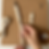 Hands creating a macrame keychain on a cork macrame board