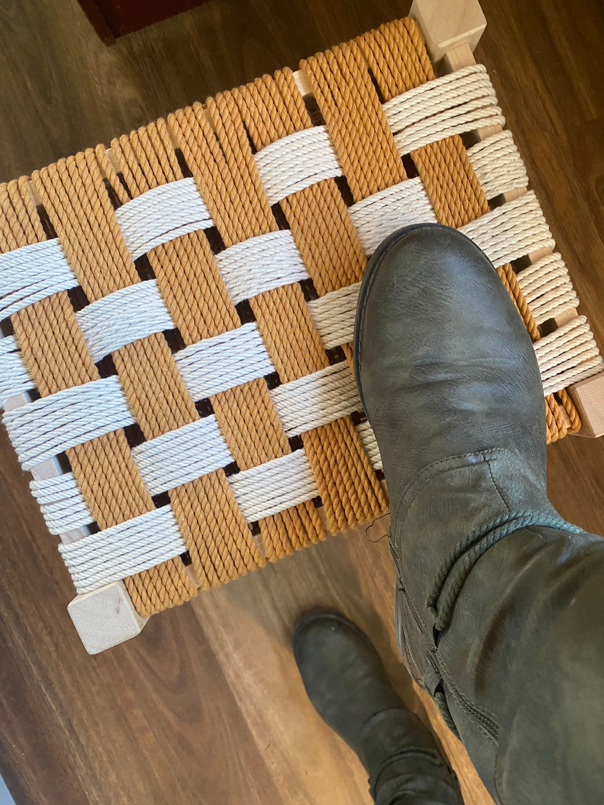 Green boot on mustard and natural wooden stool 