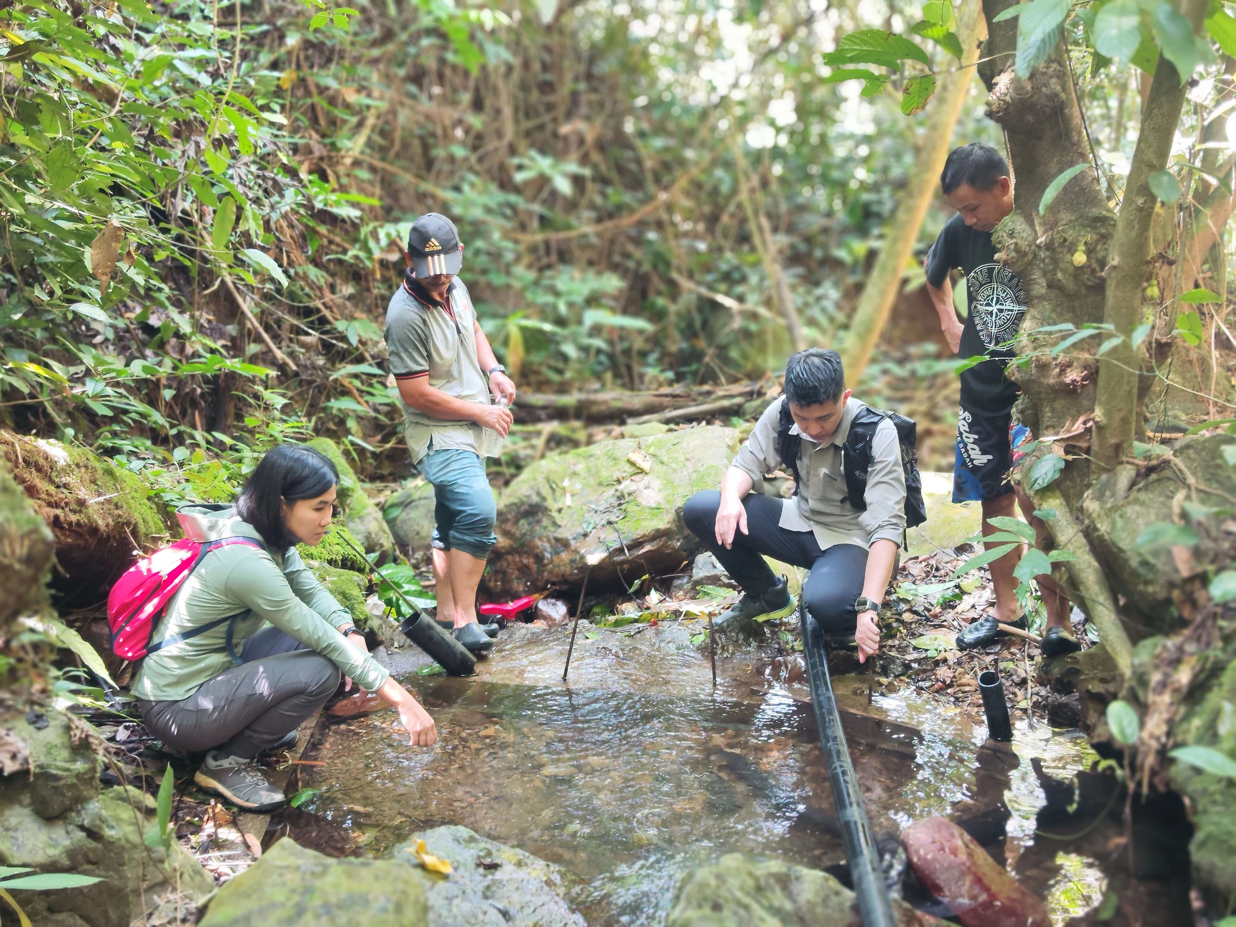Discussing efficient gravity water system integration with community members at the catchment area.