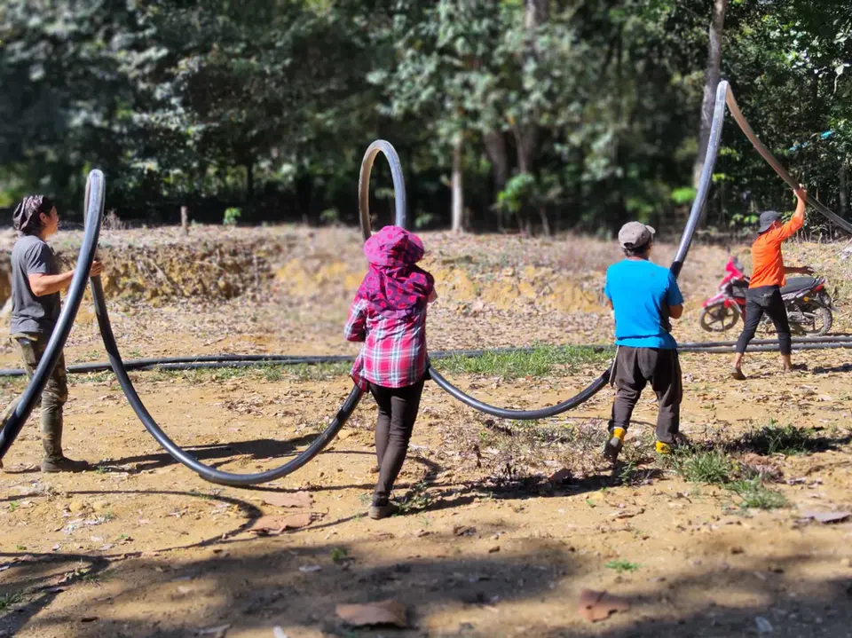 villagers carrying water pipes together