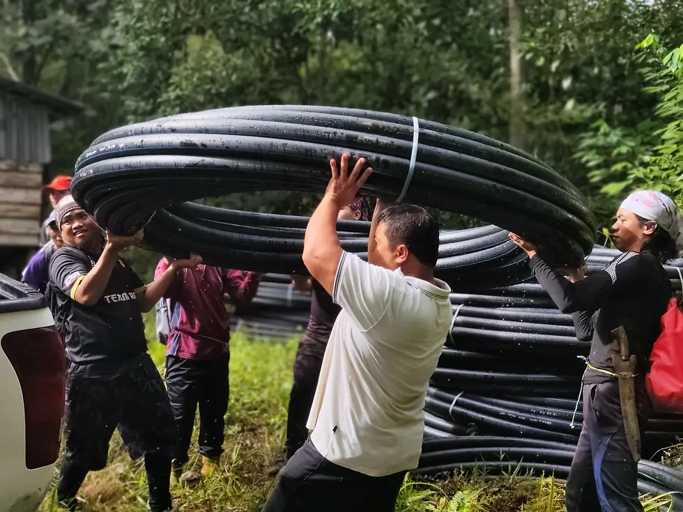rural villager carrying water pipes to water project site