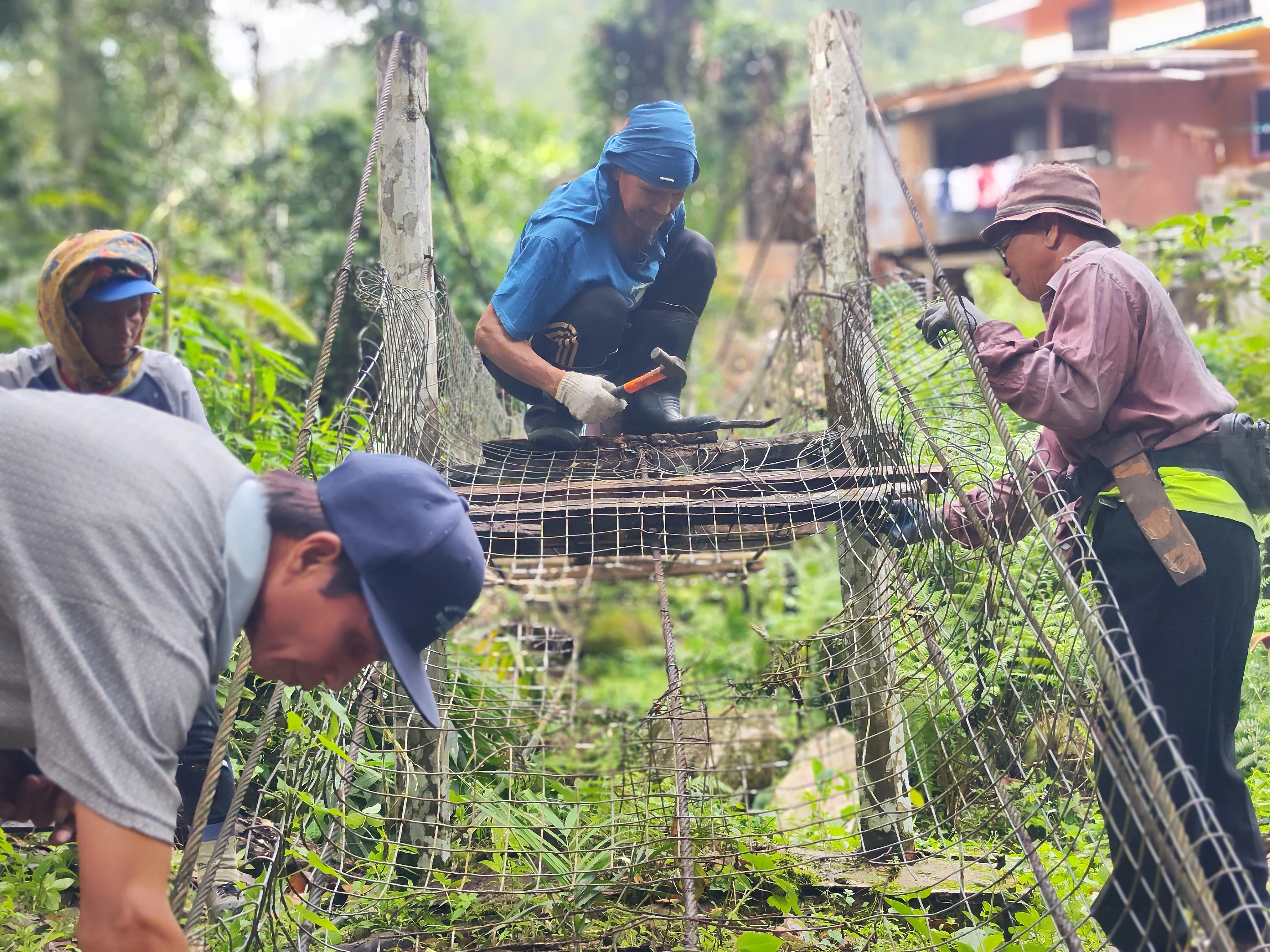 villagers working together to remove old, unwanted bridge materials to replace it with new ones