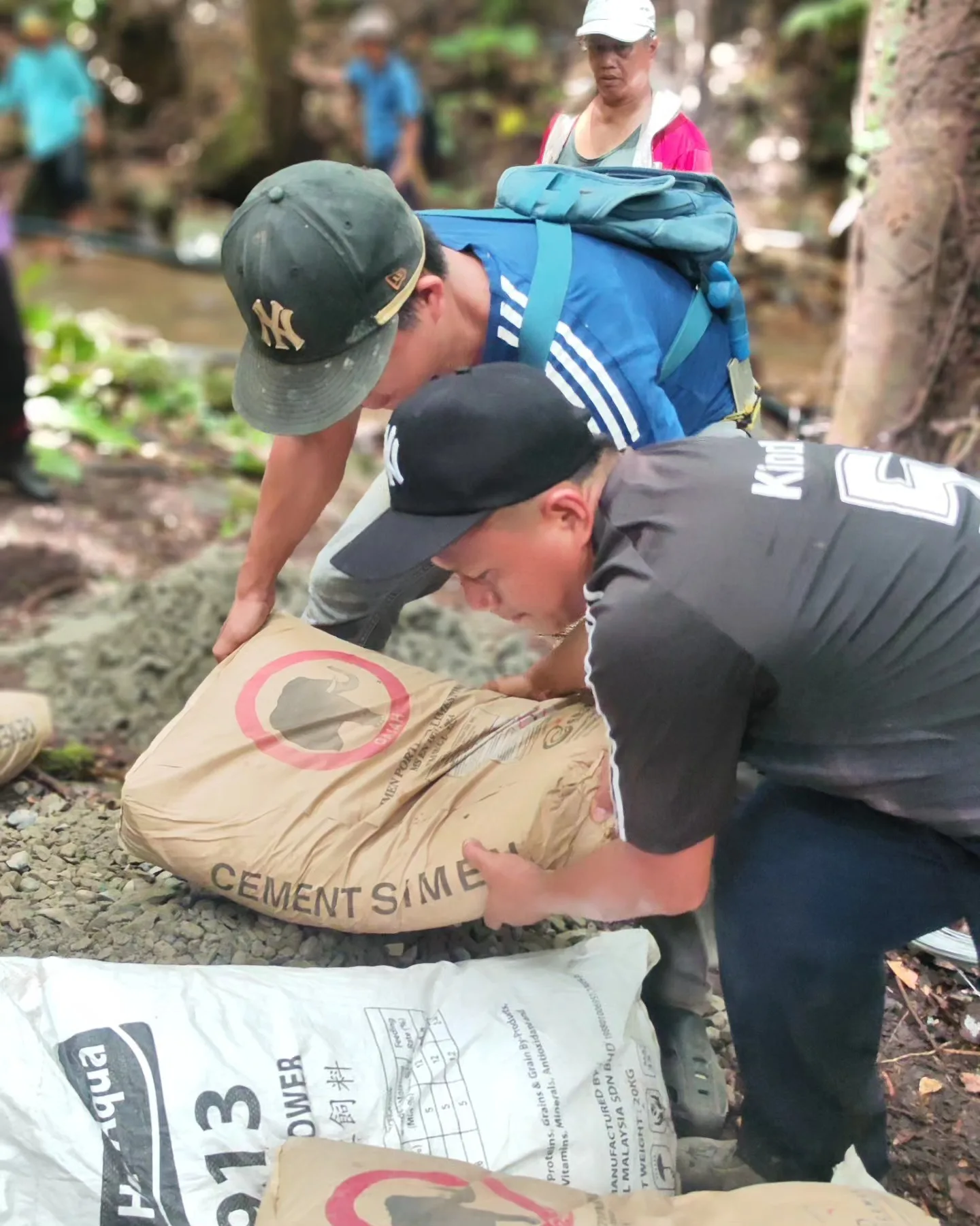 villager unloading bags of cement at the water project site