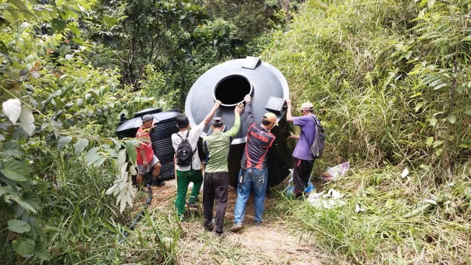 rural villagers working together to move the water tank to the project site