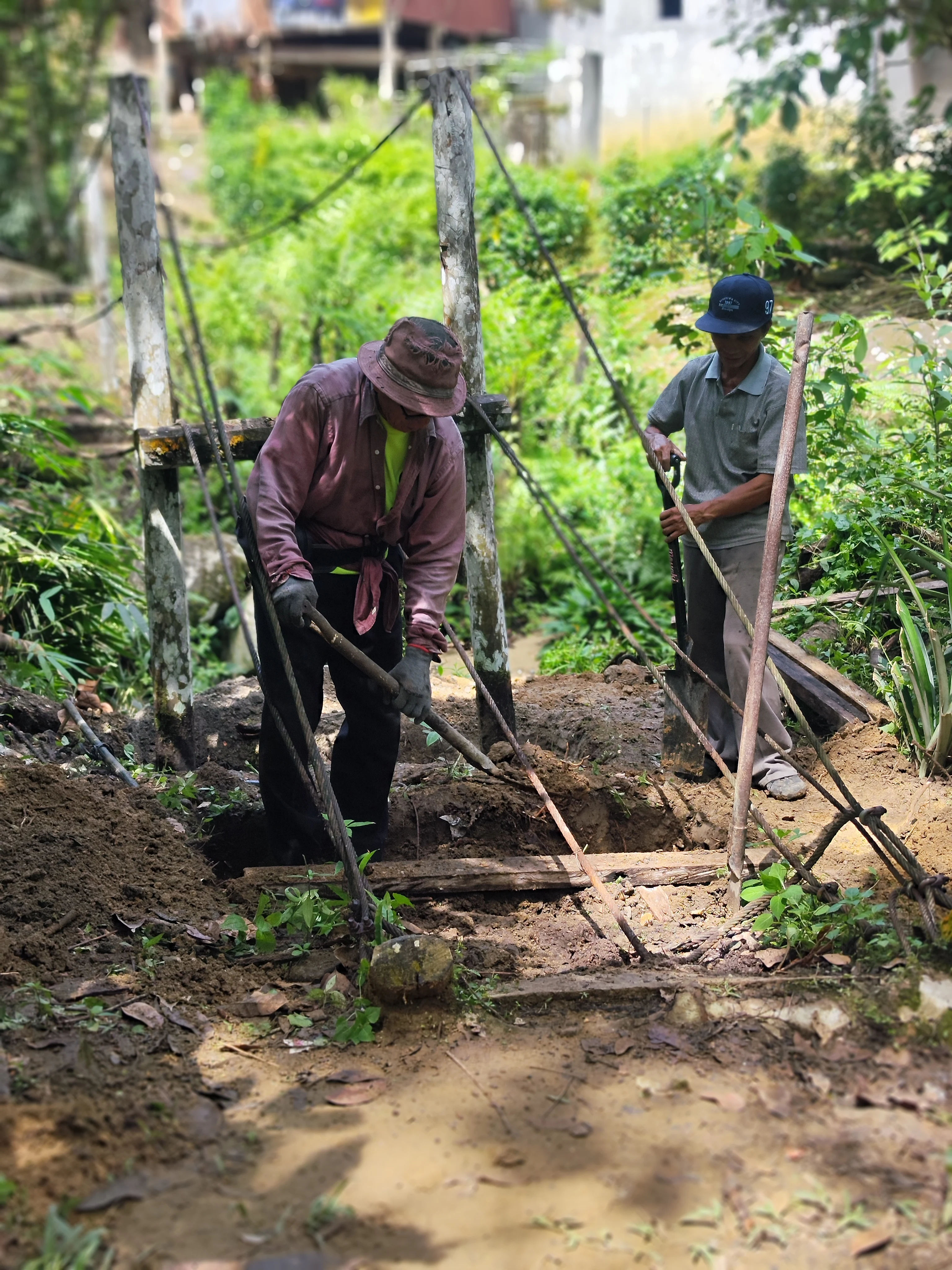 rural villagers digging a hole to build a cement bridge structure for a more study support for the bridge