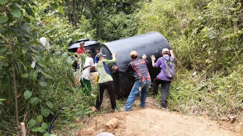 rural villagers working together to move the water tank to the project site