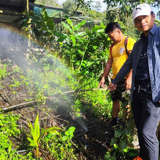 rural villagers pointing at the burst water pipe