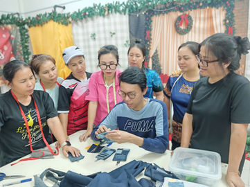 Rural women learning to create handmade card holders using upcycled materials with guidance from an in-house designer
